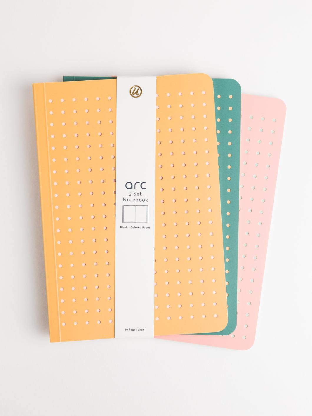 3 different colored perforated notebooks bound by a white packaging strap