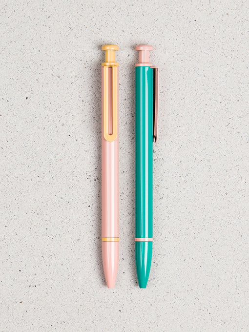 2 colorful Monterey Arc ball point click pens side by side on a speckled background